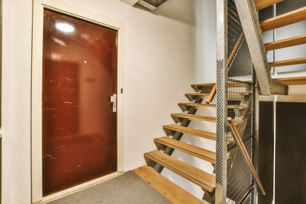 Wooden staircase in spacious hall of apartment