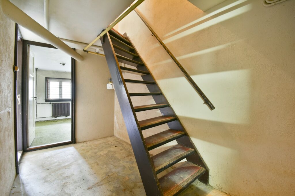 Wooden staircase in spacious hall of apartment