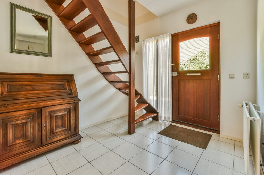 Wooden staircase in spacious hall of apartment