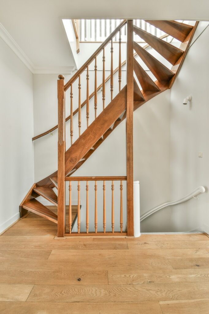 Wooden staircase in spacious hall of apartment
