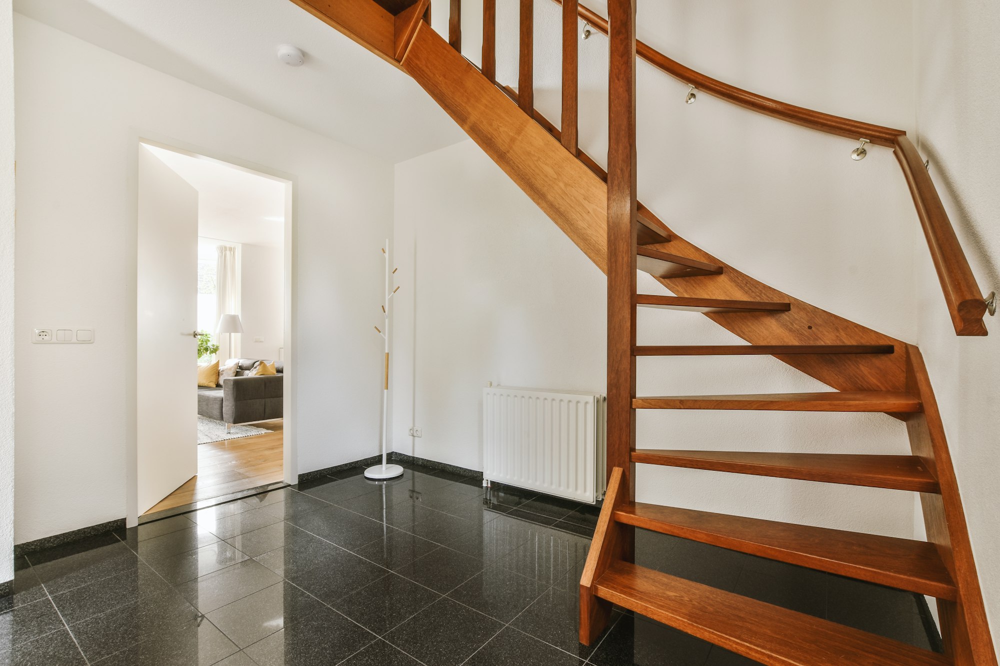 Wooden staircase in spacious hall of apartment