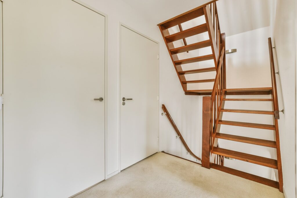 Wooden staircase in spacious hall of apartment